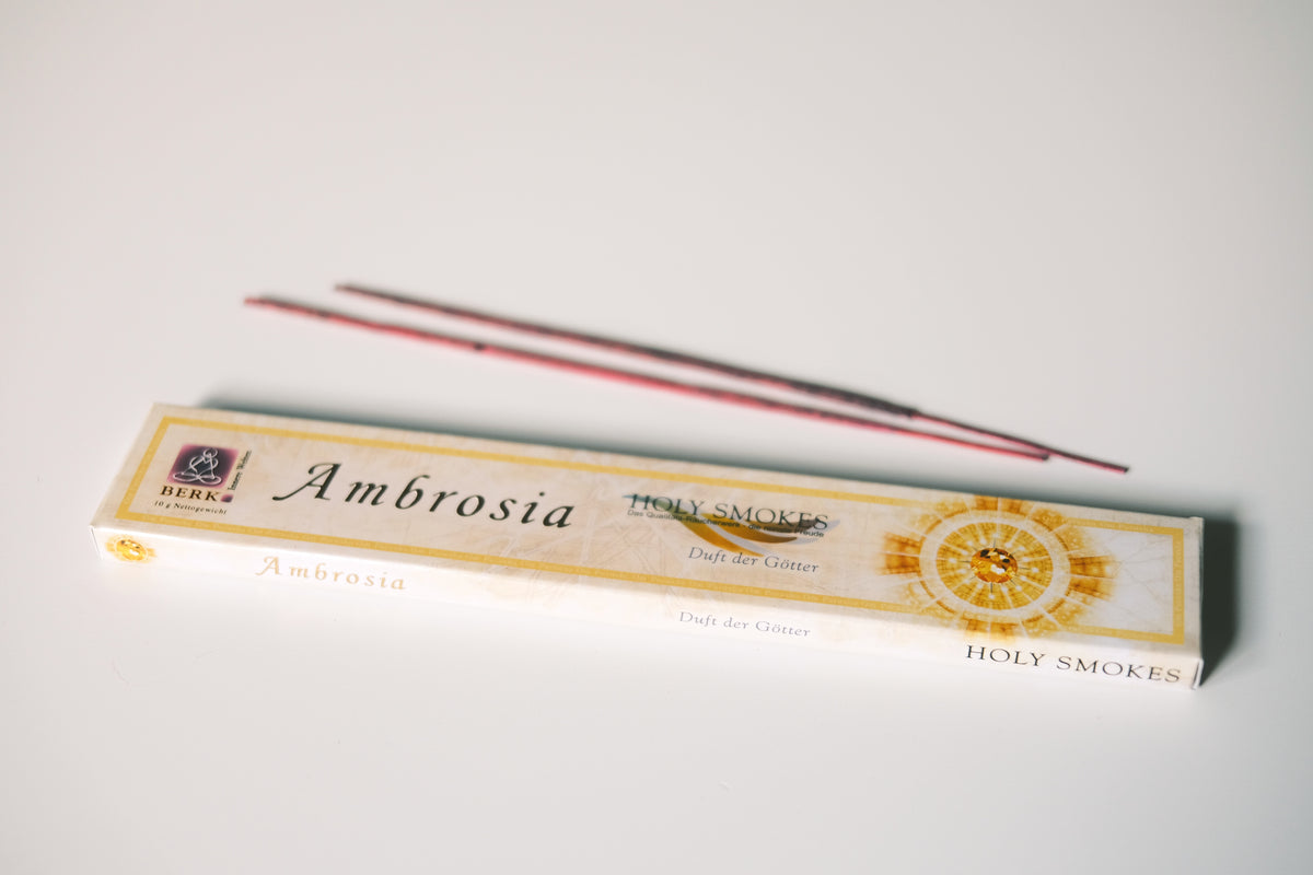 Packung Ambrosia Räucherstäbchen von Berk mit zwei losen Stäbchen auf hellem Grund